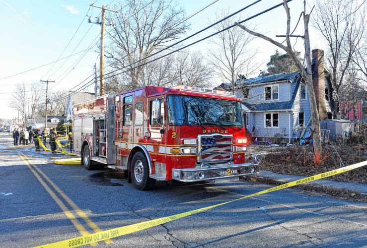 Fire crews clean up Thursday after an overnight fire heavily damaged the house at 99 West River St. in Orange.