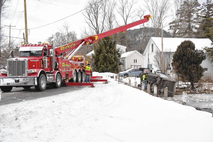 Ricky’s Towing and Recovery of Leominster prepares to hoist a dump truck out of Tully Pond along Tully Road on Friday morning.