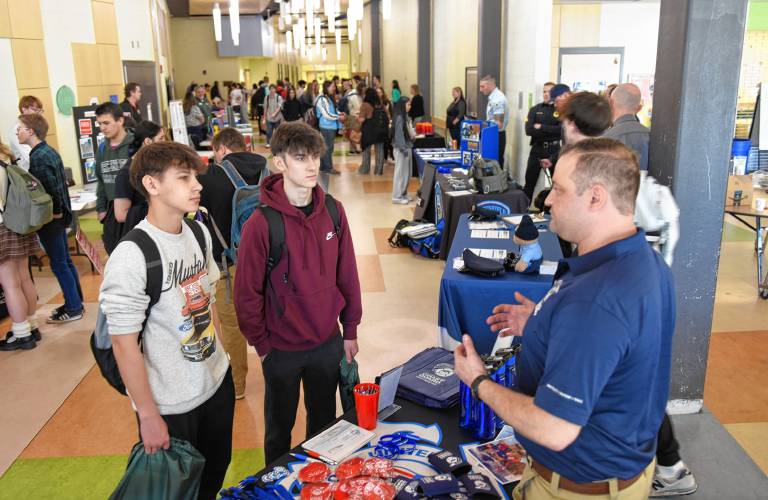 Students Maxim Kovrizhnykh and Ezeekiel Jimenez talk with Chris McCormick of the United States Coast Guard during a career fair at Greenfield High School on Friday.