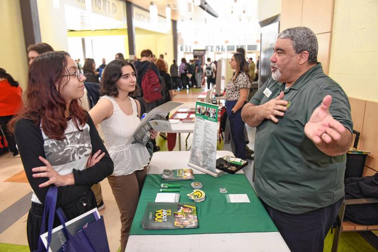 Greenfield High School juniors Maddie Mosher and Isabella Semonelli talk with Fitchburg State University Director of Admissions Tony Trodella during a career fair at the school on Friday.