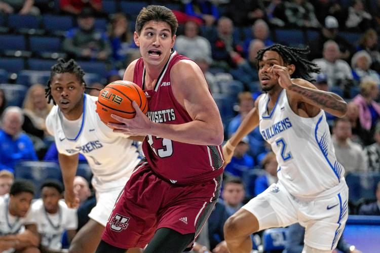 Massachusetts' Josh Cohen (23) heads to the basket as Saint Louis' Bradley Ezewiro, left, and Larry Hughes II (2) defend earlier this season in St. Louis. Massachusetts' Josh Cohen (23) heads to the basket as Saint Louis' Bradley Ezewiro, left, and Larry Hughes II (2) defend earlier this season in St. Louis.