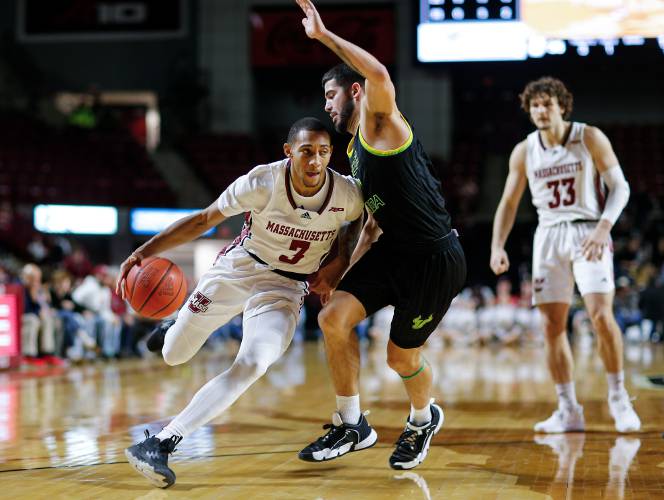UMass guard Rahsool Diggins (3) drives the ball against South Florida’s Jose Placer (2) in the second half on Dec. 2, 2023, at the Mullins Center in Amherst.