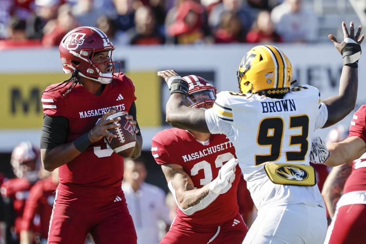 UMass quarterback Taisun Phommachanh (3) prepares to make a pass while running back CJ Hester (33) keeps Missouri defensive end Jaylen Brown (93) away during action earlier this season in Amherst. UMass quarterback Taisun Phommachanh (3) prepares to make a pass while running back CJ Hester (33) keeps Missouri defensive end Jaylen Brown (93) away during action earlier this season in Amherst.