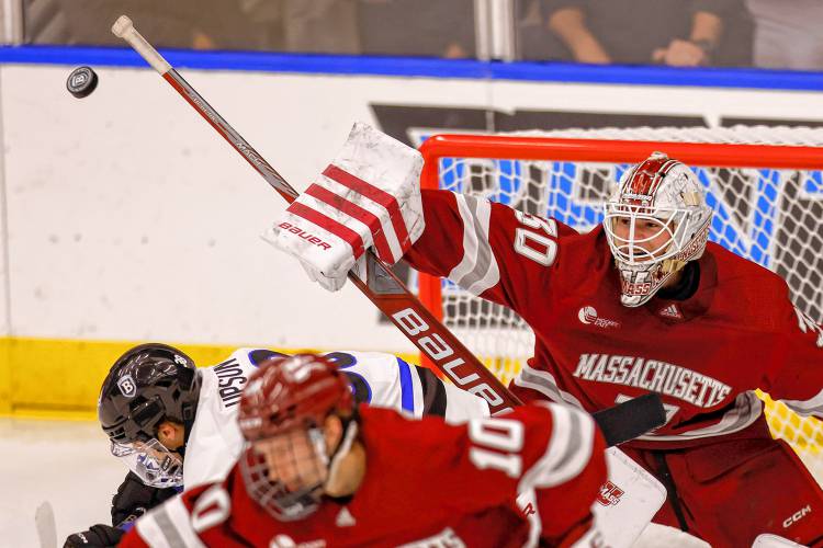 Massachusetts goalie Michael Hrabal (30) deflects a shot while Bentley forward Ryan Upson (38) and forward Dans Locmelis (10) duck out of the way during the second period of a game on Oct. 5 in Waltham. Massachusetts goalie Michael Hrabal (30) deflects a shot while Bentley forward Ryan Upson (38) and forward Dans Locmelis (10) duck out of the way during the second period of a game on Oct. 5 in Waltham.