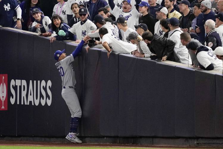Fans interfere with a foul ball caught by Los Angeles Dodgers right fielder Mookie Betts during Game 4 of the World Series against the Yankees on Oct. 29. Fans interfere with a foul ball caught by Los Angeles Dodgers right fielder Mookie Betts during Game 4 of the World Series against the Yankees on Oct. 29.