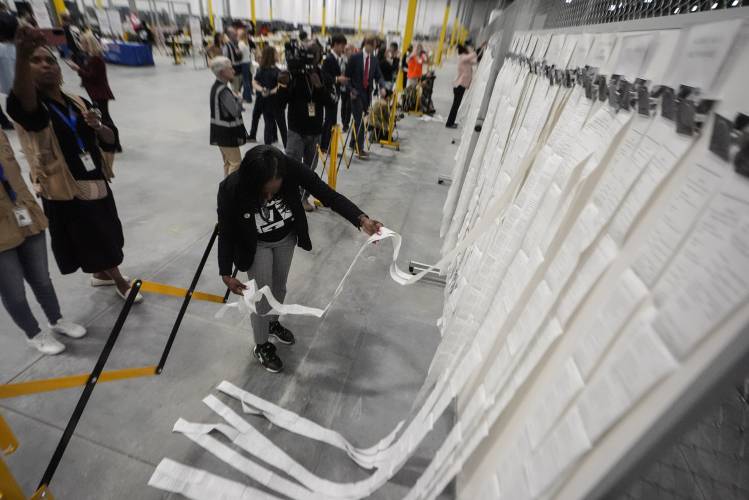 An elections staffer hangs scanner tapes used in early voting at the Fulton County Election Hub and Operation Center, Tuesday, Nov. 5, 2024, in Atlanta. An elections staffer hangs scanner tapes used in early voting at the Fulton County Election Hub and Operation Center, Tuesday, Nov. 5, 2024, in Atlanta.