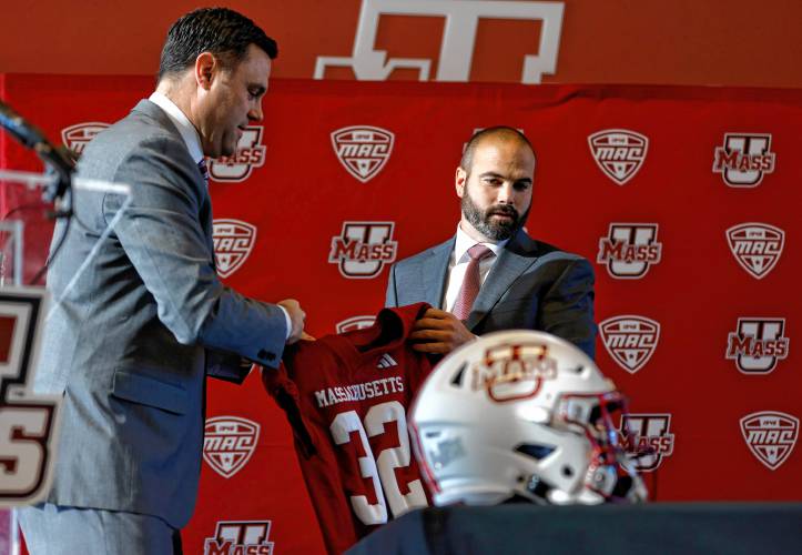 Joe Harasymiak, right, receives a jersey from Athletics Director Ryan Bamford as the 32nd UMass head football coach on Friday during a press conference at the Martin Jacobson Football Performance Center in Amherst. Joe Harasymiak, right, receives a jersey from Athletics Director Ryan Bamford as the 32nd UMass head football coach on Friday during a press conference at the Martin Jacobson Football Performance Center in Amherst.
